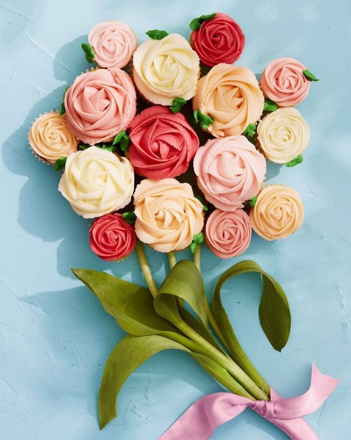 vanilla cupcakes with frosting piped to look like flowers and arranged in the shape of a bouquet