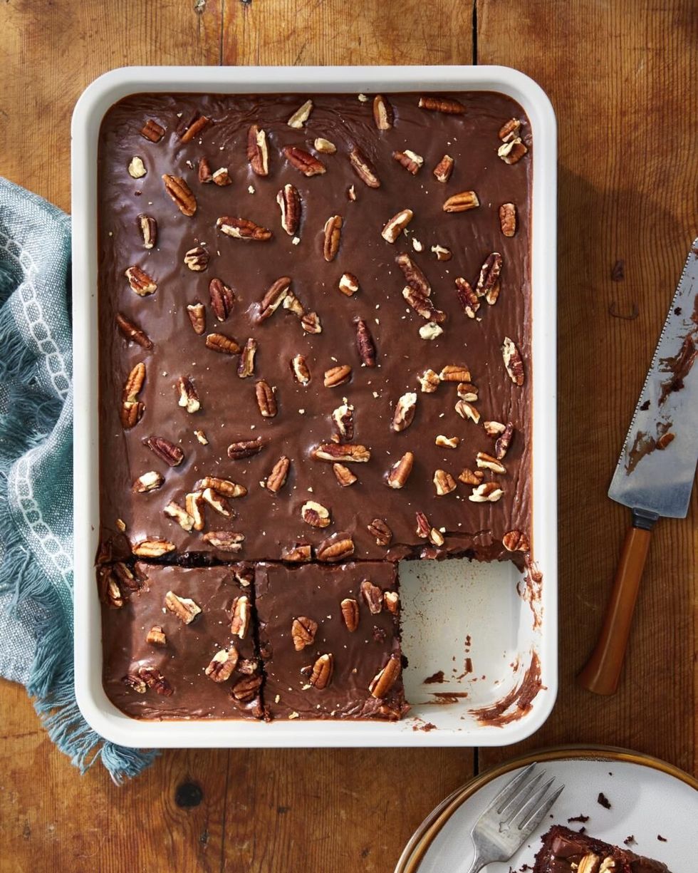 a chocolate sheet cake with chocolate frosting and pecans on top