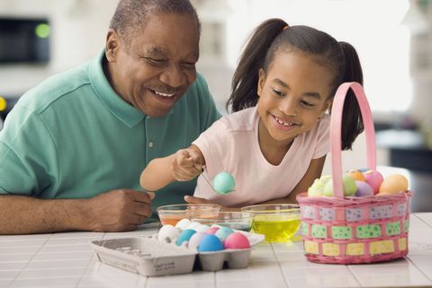 man and girl dyeing easter eggs
