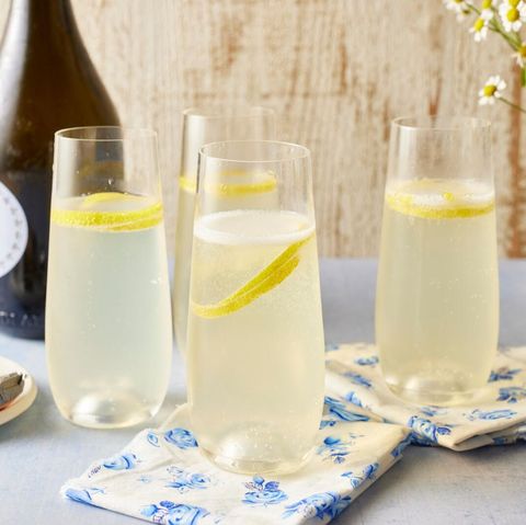 french 75 cocktail with lemon zest on blue floral napkin