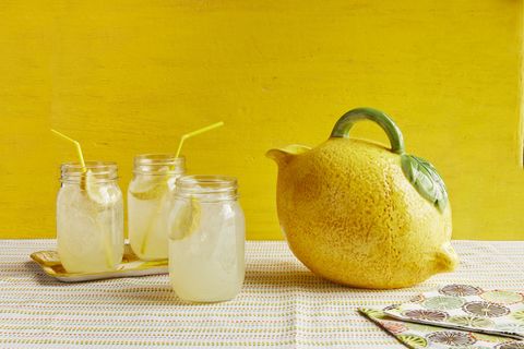 sparkling ginger lemonade in jars with straws yellow background