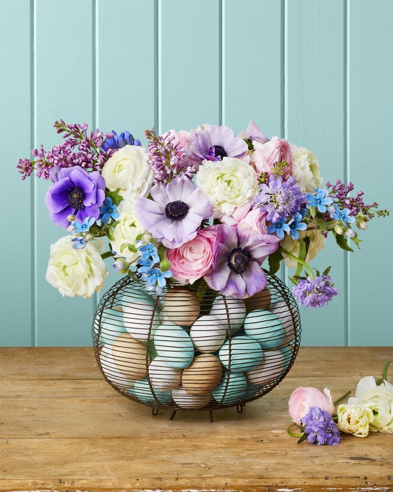 bouquet of flowers in basket filled with easter eggs