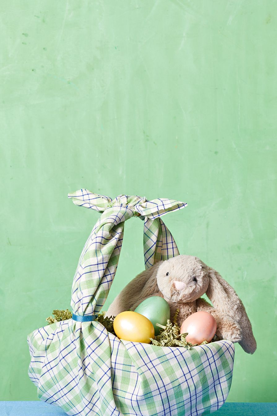 easter crafts, plaid fabric wrapped basket with a teddy bunny and colorful eggs inside