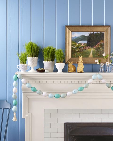easter mantel display with grass growing from milkglass vessles