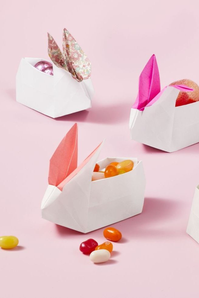easter crafts, white paper shaped into origami bunnies with candy inside