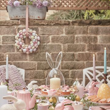 a table filled with easter decorations, including egg decorations, candles and cakes