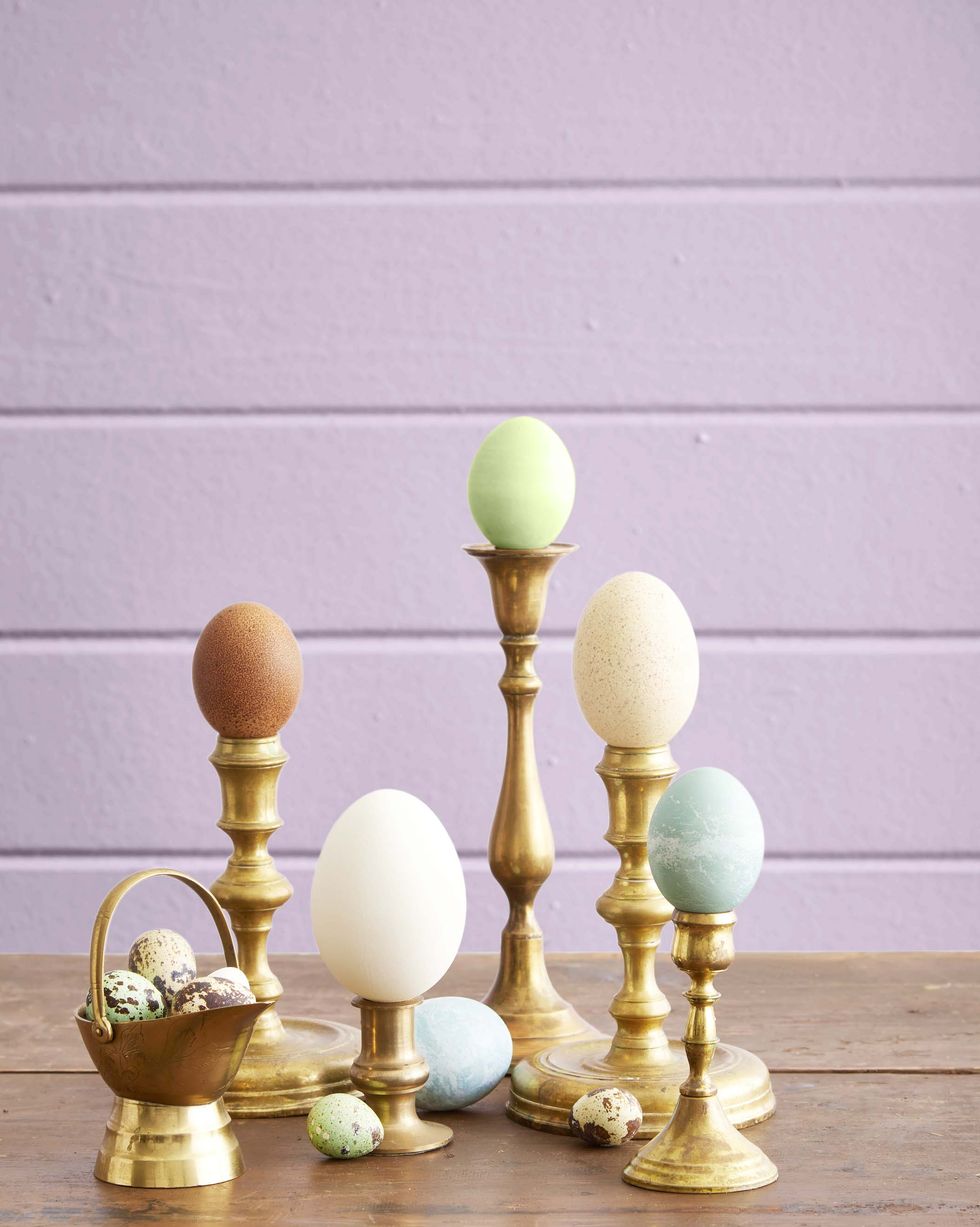 easter eggs displayed on vintage brass candlesticks