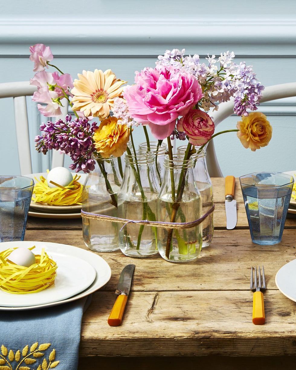 centro de mesa de pascua con botellas de cristal y flores