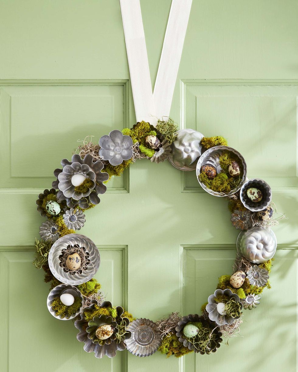a wreath made from vintage tart tins that are filled with moss and mini eggs