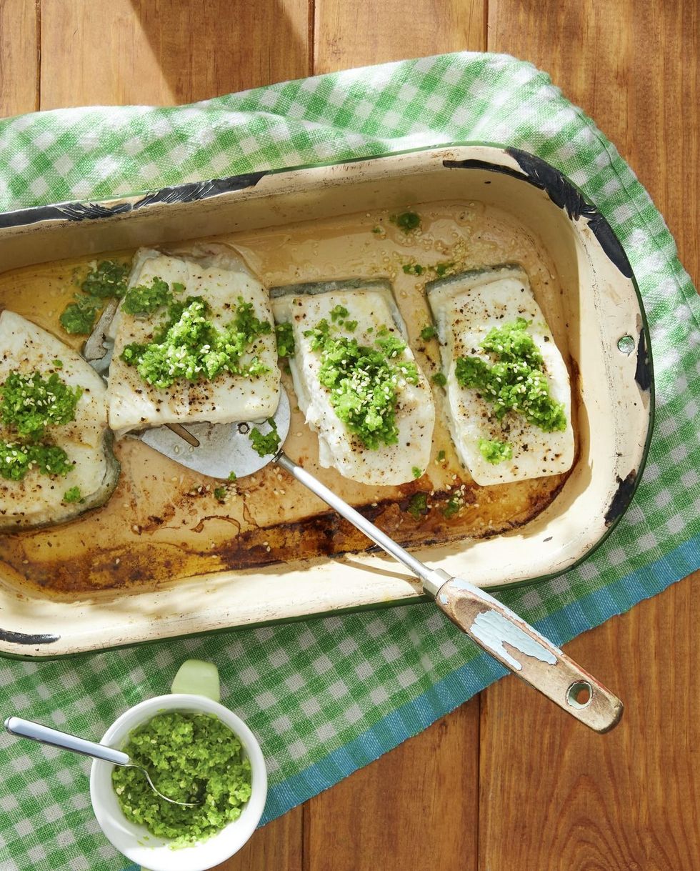 baked halibut with snap pea and toasted sesame gremolata on top and arranged in a white baking dish