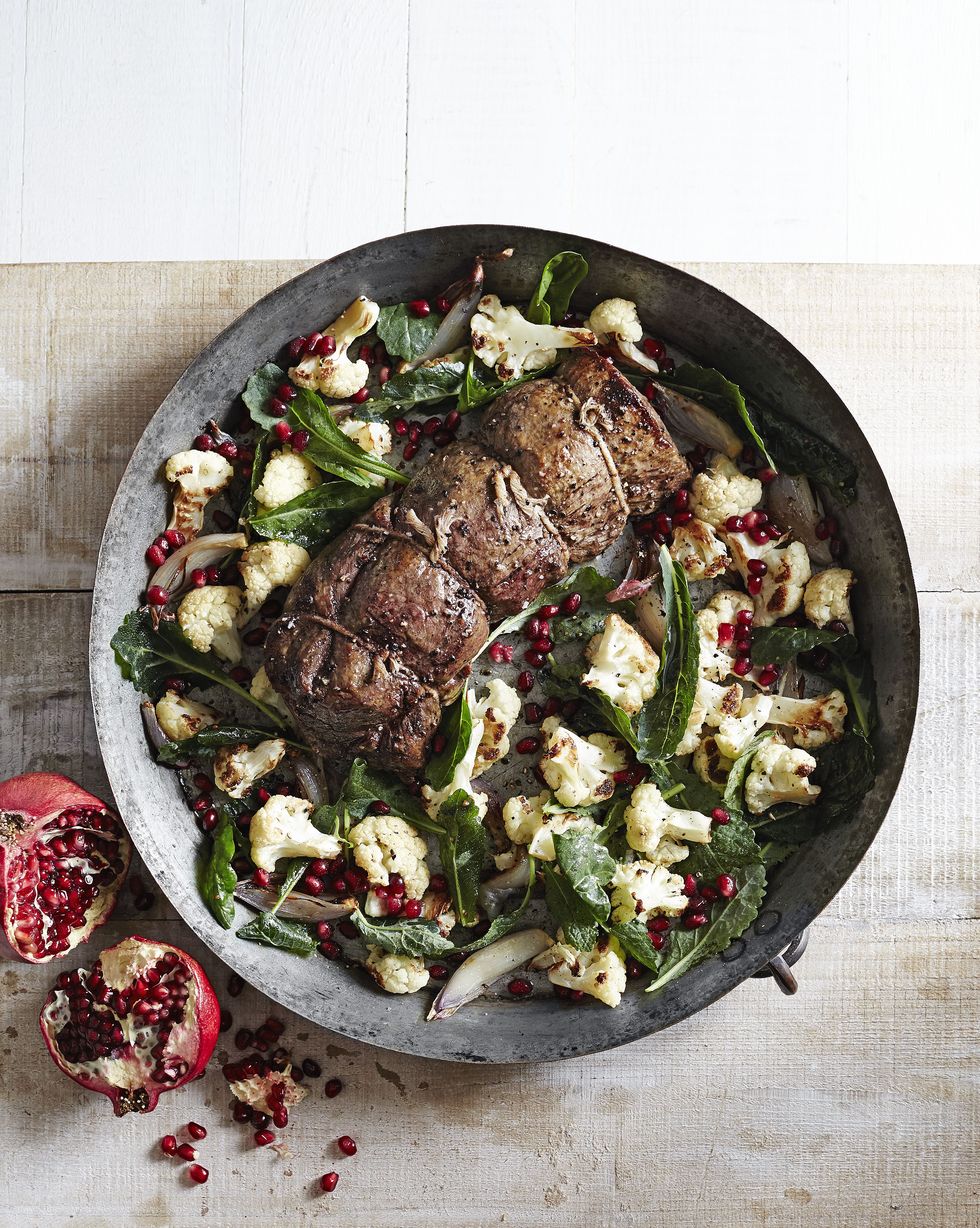 beef tenderloin with roasted cauliflower salad in a large metal serving bowl