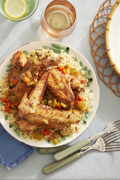 braised turkey wings over rice on a serving plate with utensils