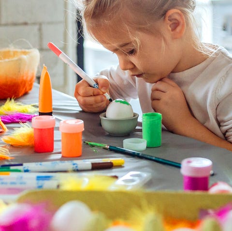 young girl decorating easter eggs