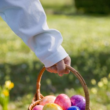 boy holding a basket of multicoloured easter eggs