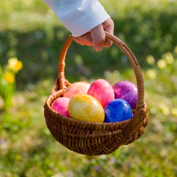 boy holding a basket of multicoloured easter eggs