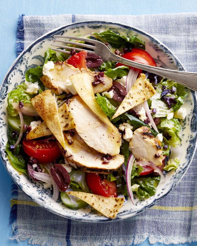 greek salad with chicken overhead on blue linen