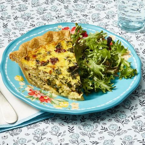 sausage and kale quiche on blue plate with salad
