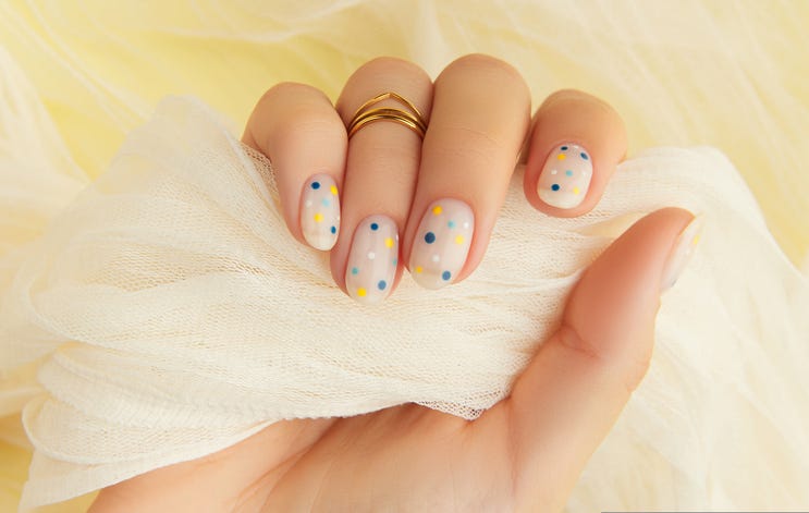 womans hand with trendy polka dot summer manicure beauty treatment spa body care concept