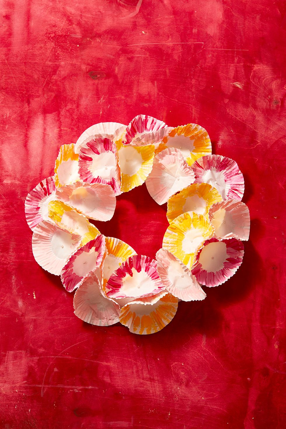 easter crafts, painted cupcake liner wreath against red background
