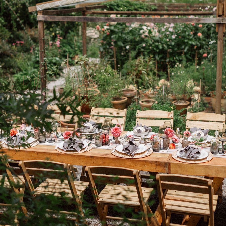 a table in a garden that is set for a feast