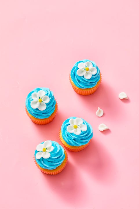 blue flower cupcakes on a pink background