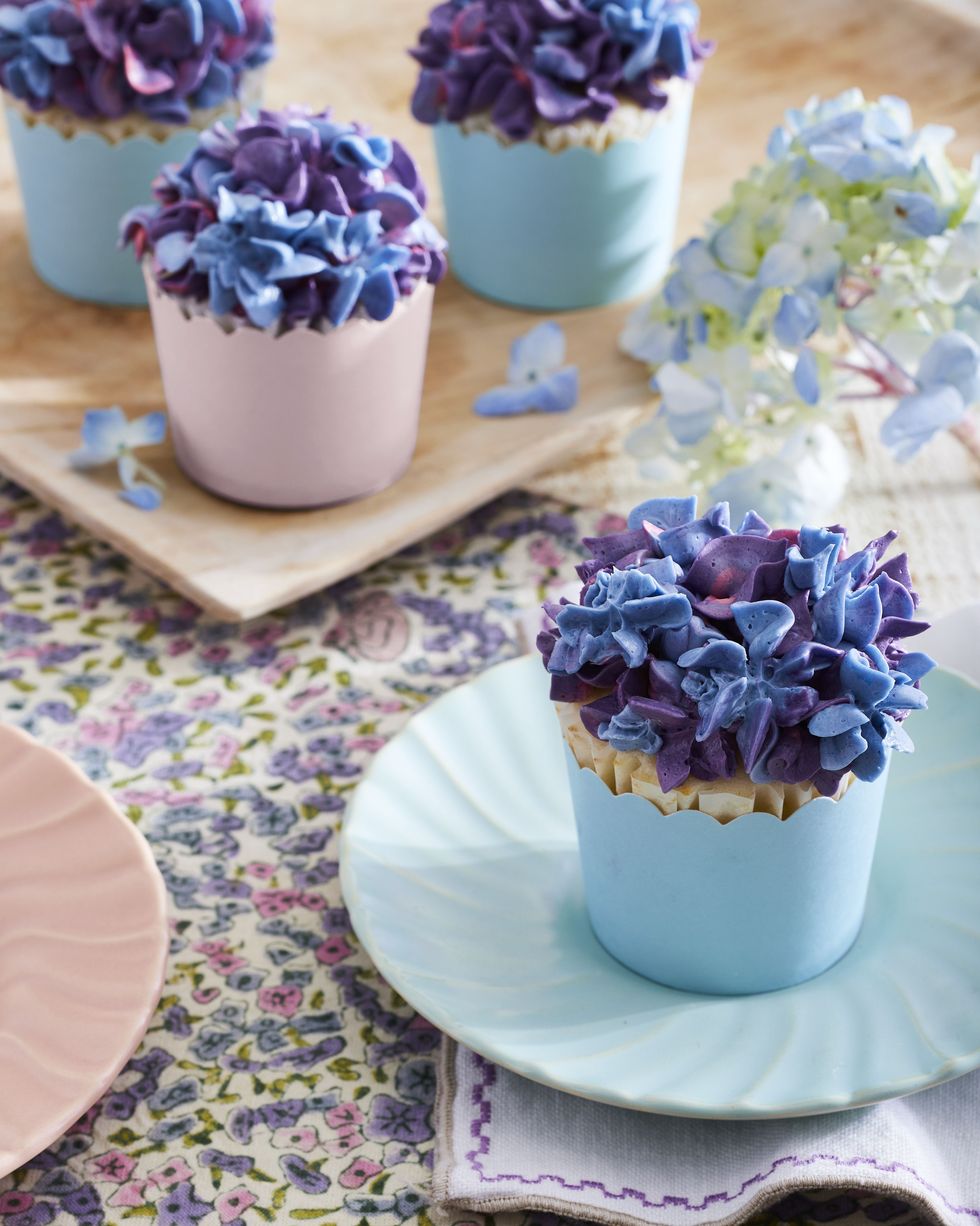buttermilk lime cupcakes in blue and pink pastel cupcake liners and topped with blue and purple frosting piped to look like lilacs