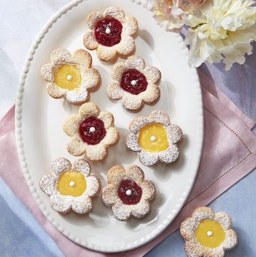 flower shaped fruit tarts with lemon curd and raspberry fillings in the center