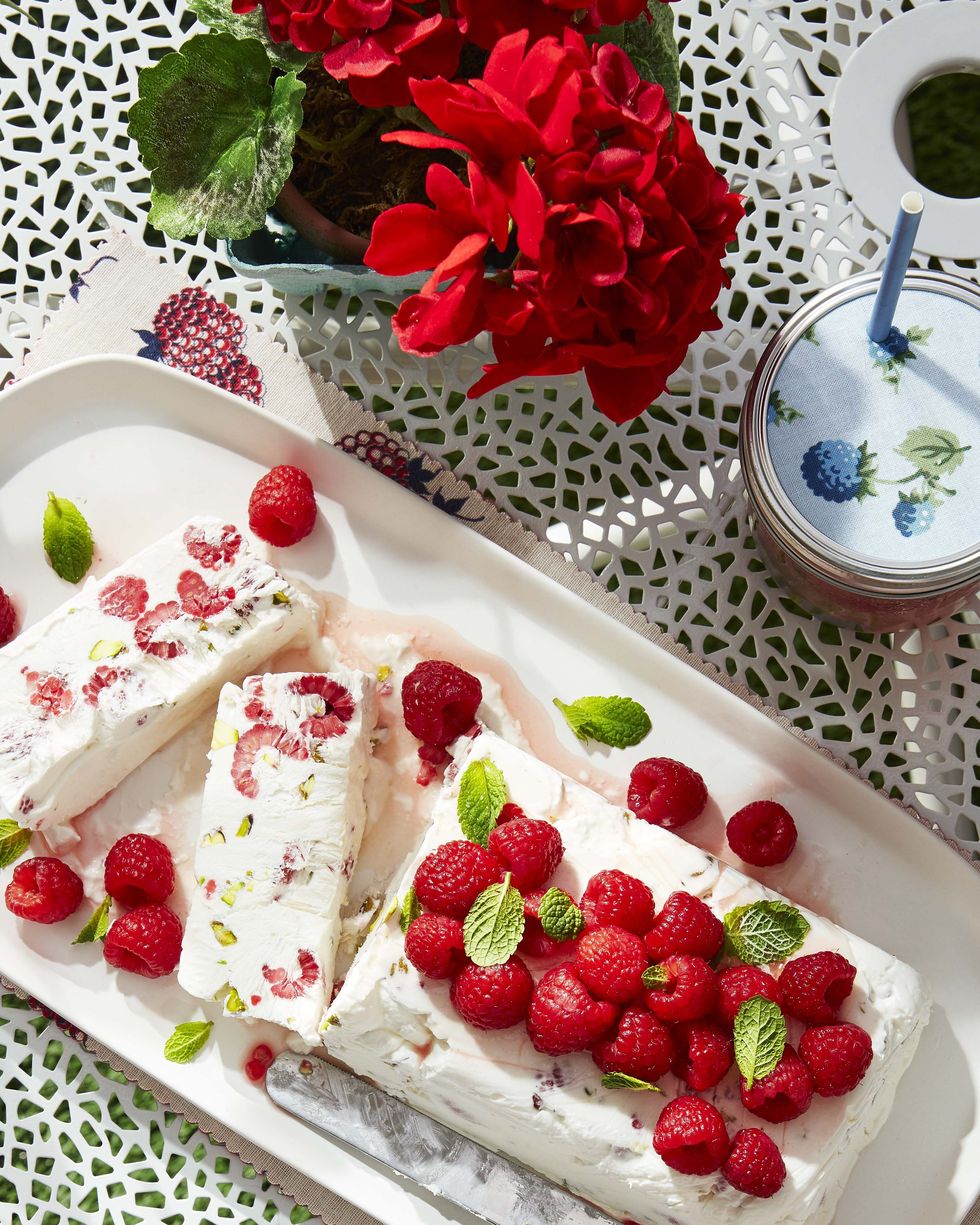 raspberry and pistachio semifreddo with fresh raspberries and mint leaves on top