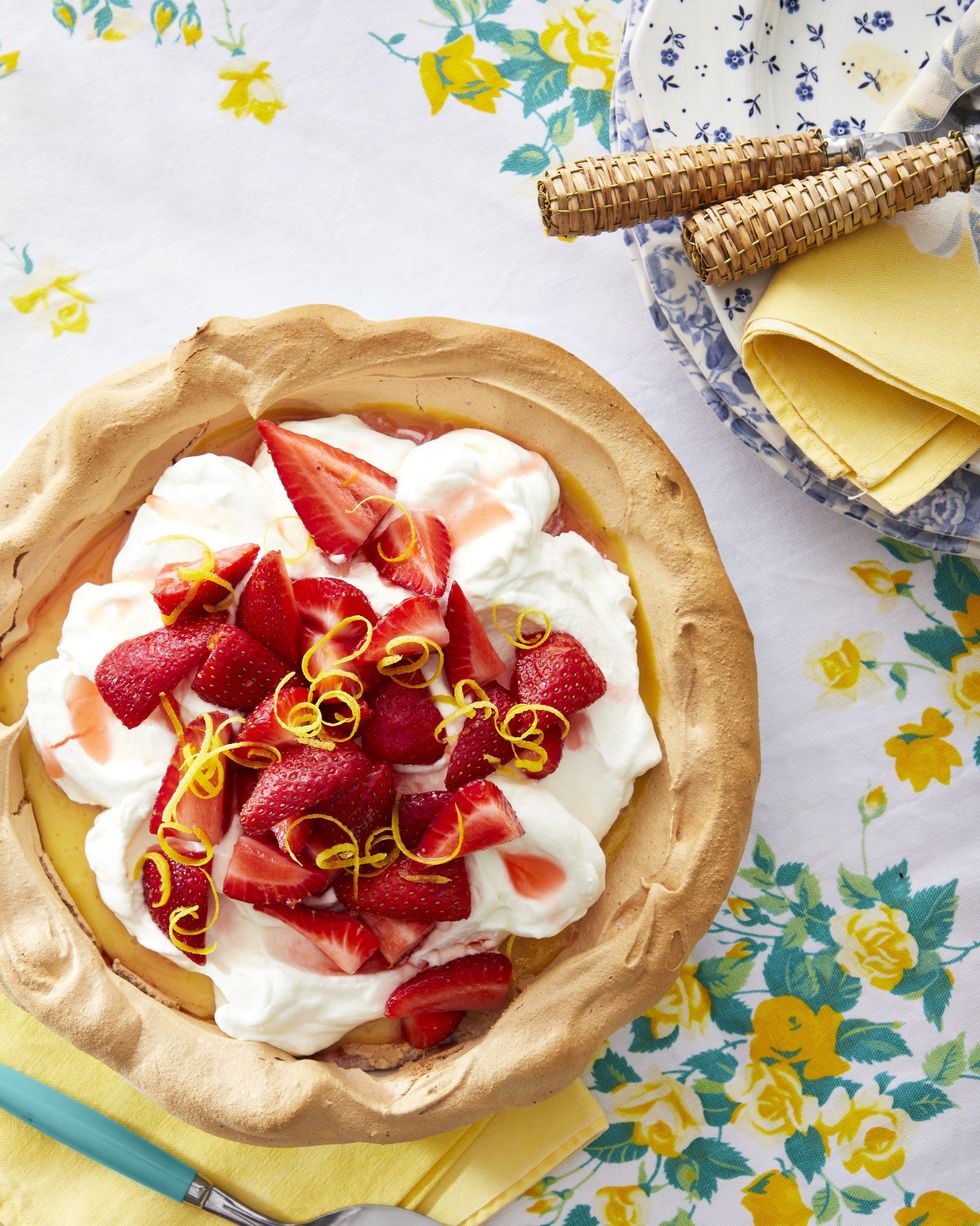 strawberry lemonade angel pie with a meringue crust and topped with whipped cream and sliced strawberries and lemon zest