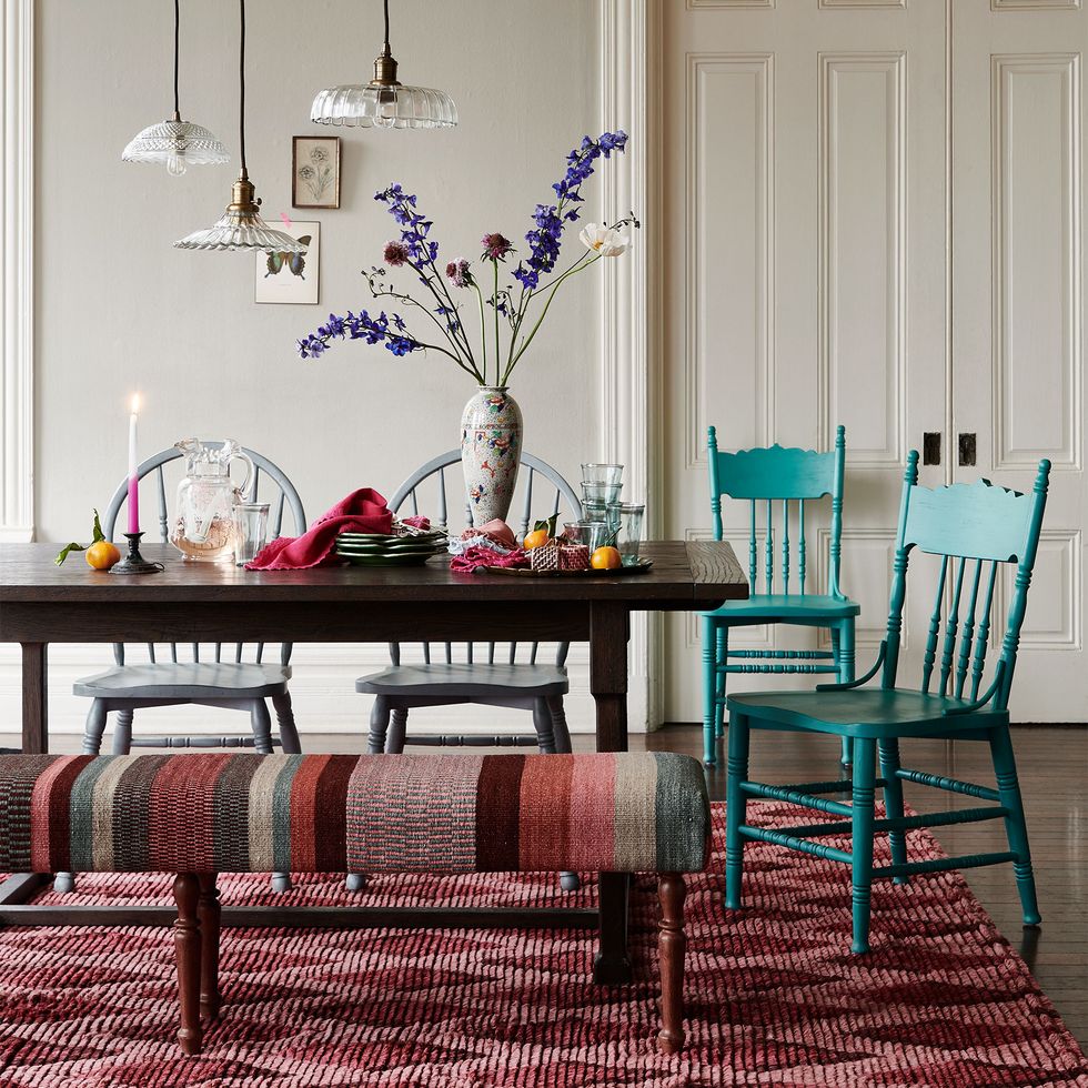dining room with red diamond shape rug and stripe bench
