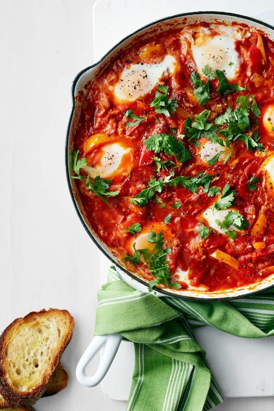 stewed peppers and tomatoes with eggs in skillet with bread