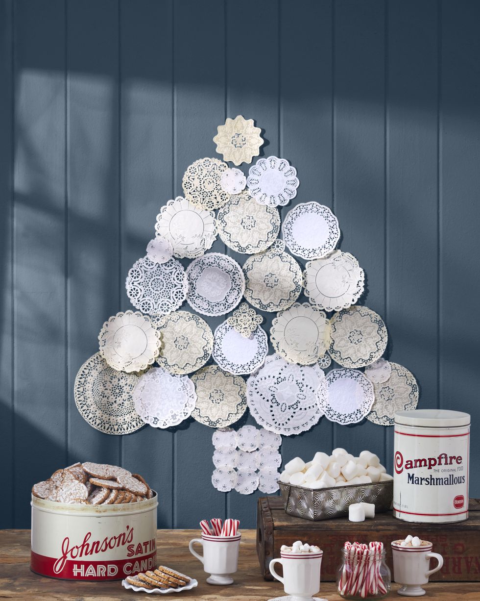 Vintage doilies arranged on a blue wall in the shape of a Christmas tree