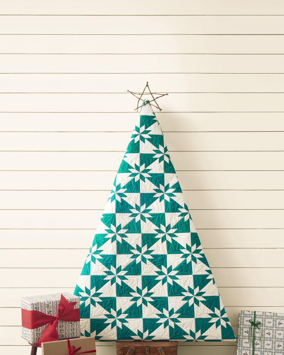 Place a triangular quilt shaped like a Christmas tree in a wooden picnic basket and surround it with wrapped presents.