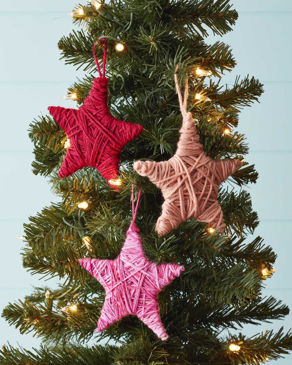 star shapes wrapped in yarn and hung on a tree as christmas ornaments