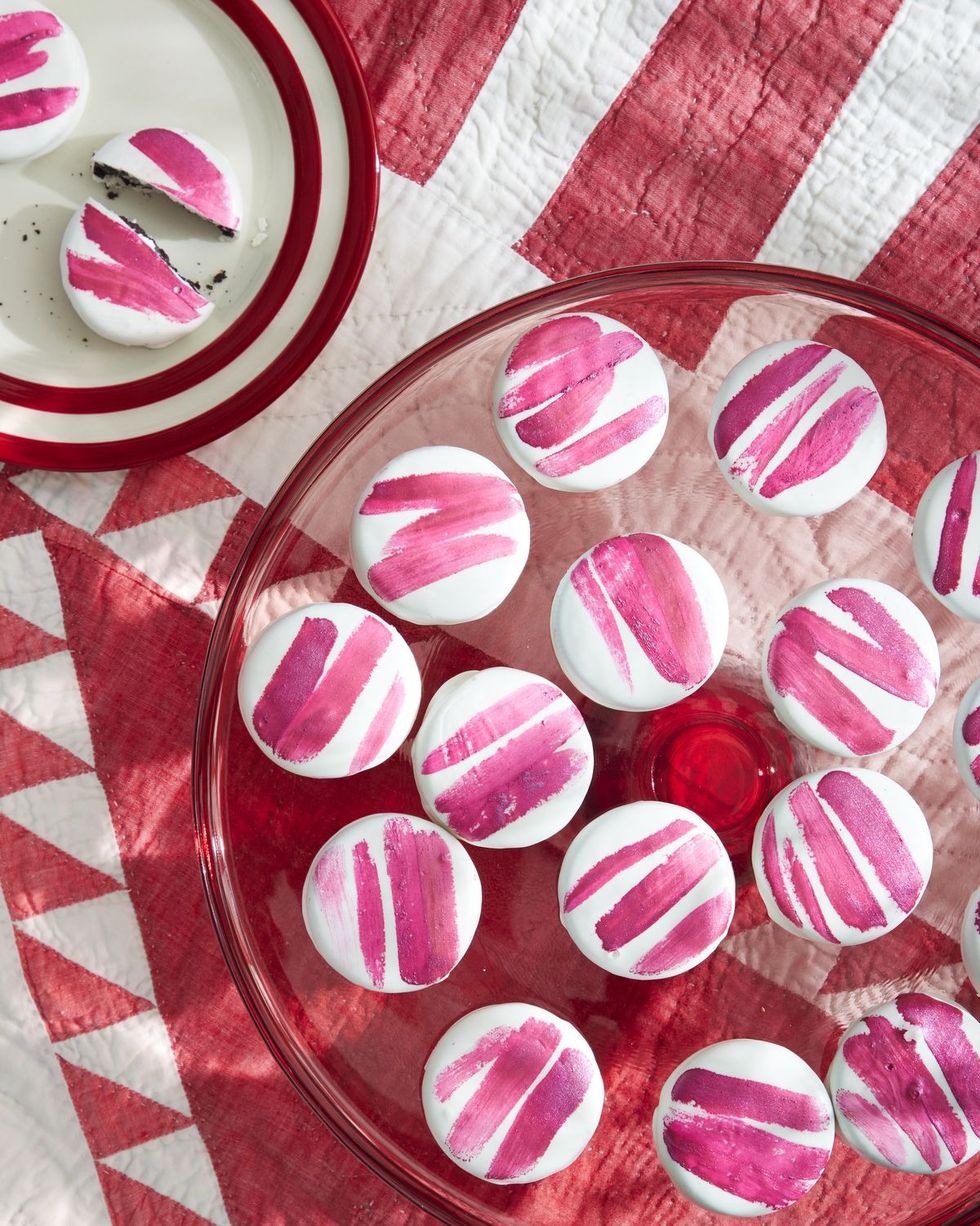 striped peppermint sandwich cookies dipped in white candy coating with painted stripes on top