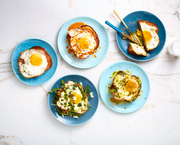 several blue plates with a variety of egg toasts