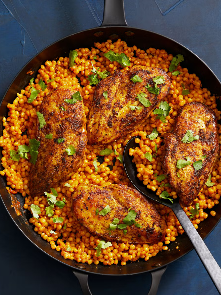 moroccan spiced chicken and couscous in a skillet
