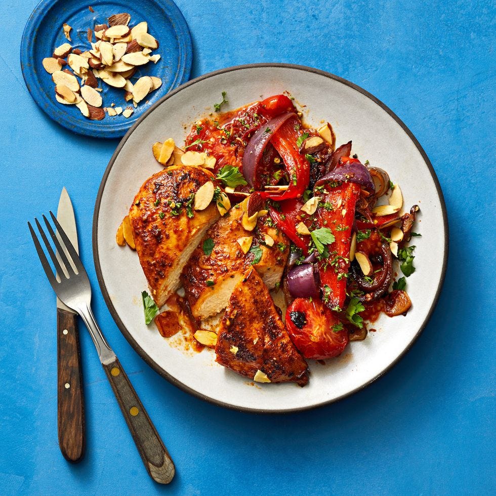 paprika chicken with peppers and tomatoes served on a white plate