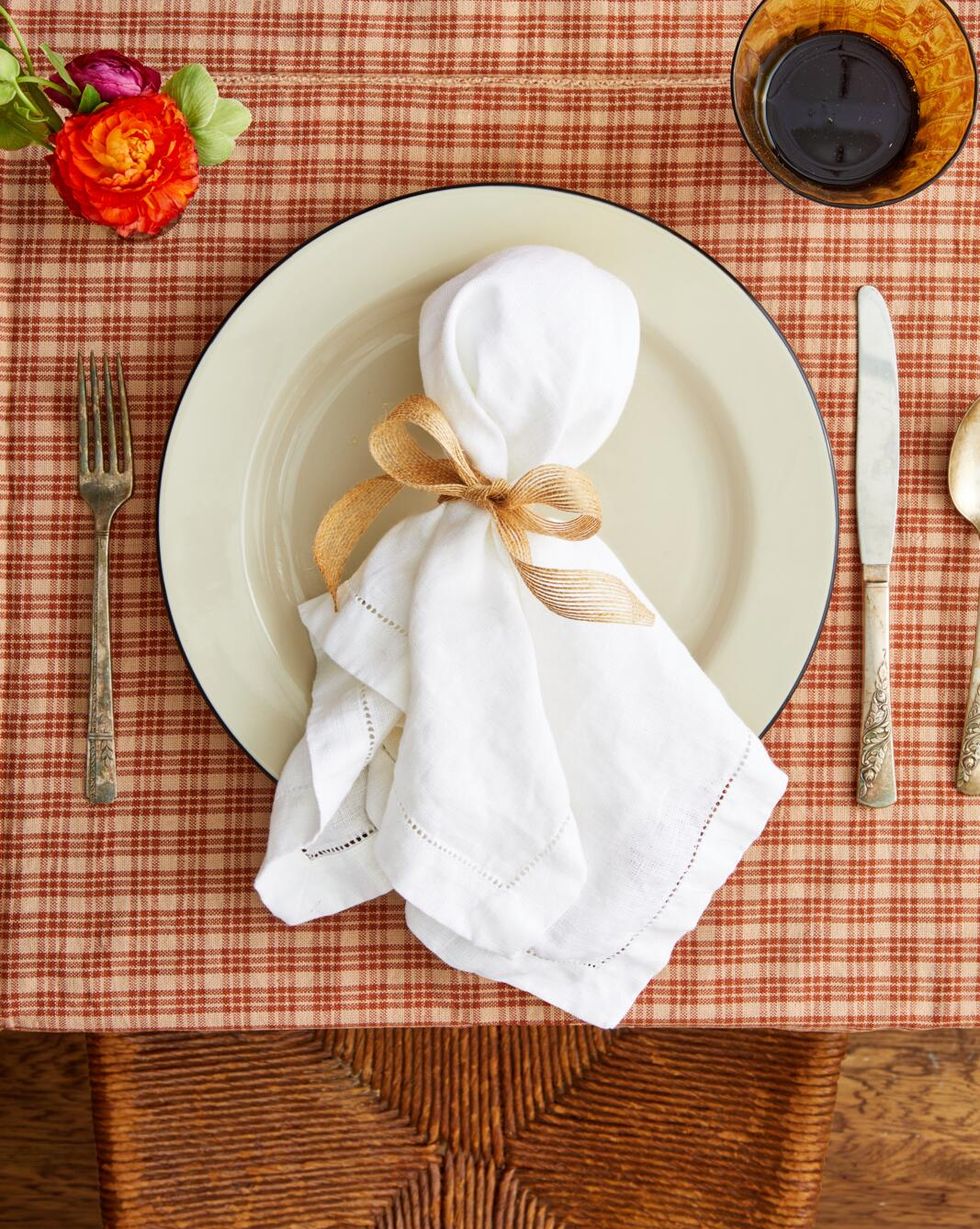 a white linen napkin folded around a piece of tissue and tied with a piece of ribbon to look like a ghost