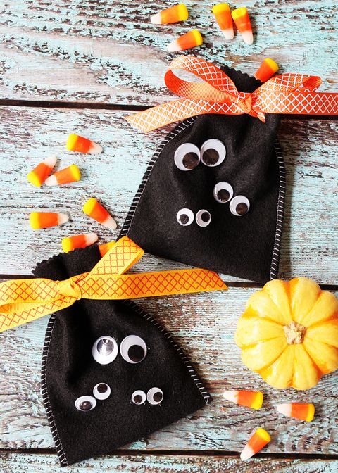 black felt kids candy pouches with handstitched sides, decorated with googly eyes, and tied with orange ribbon