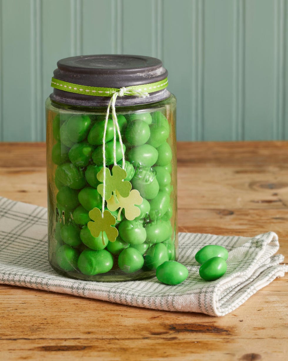 green mason jar filled with green candy and four leaf clover tags hanging on the outside