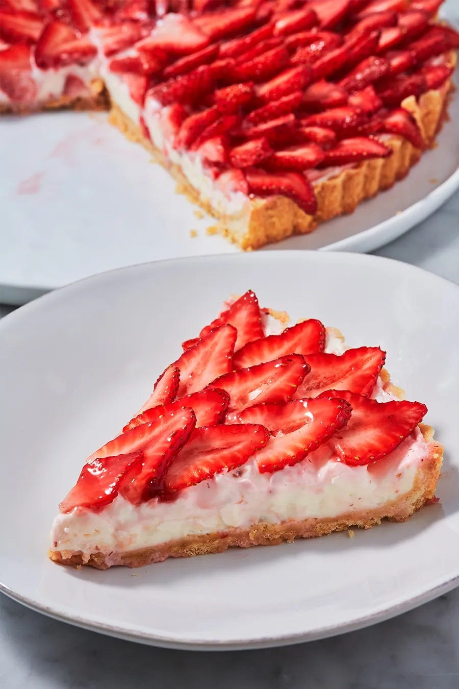 strawberry tart with slices of layered strawberries on top