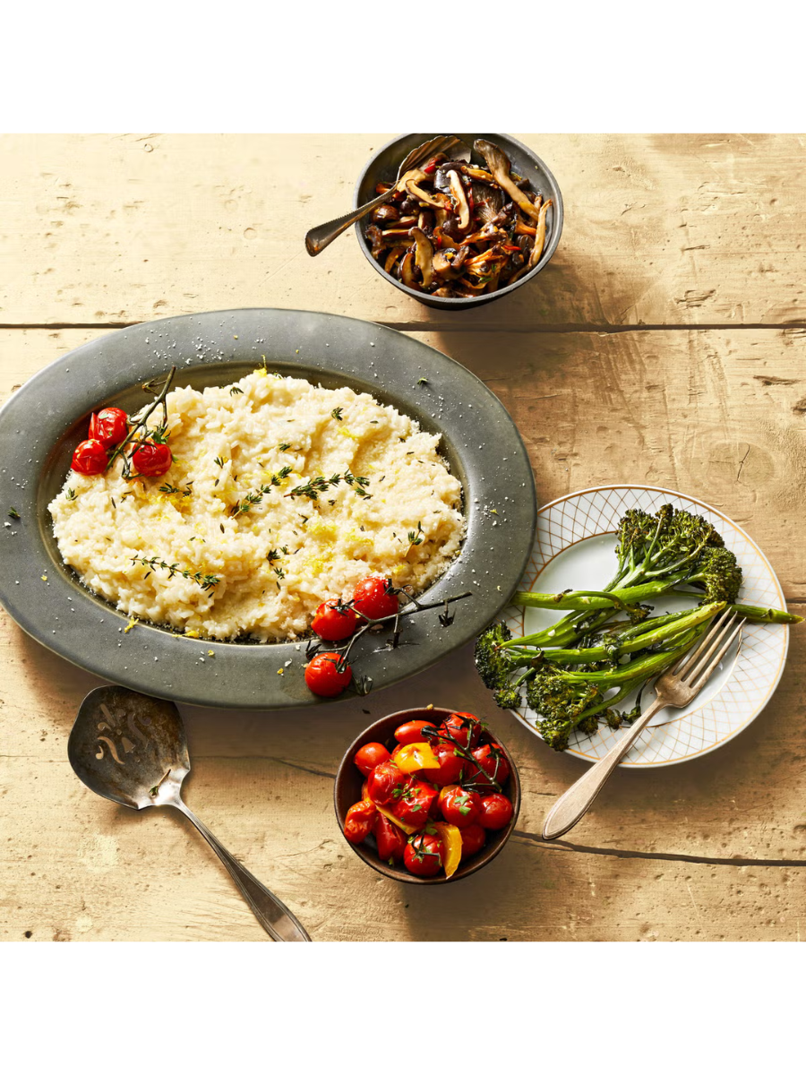 a bowl of risotto and roasted tomatoes on top