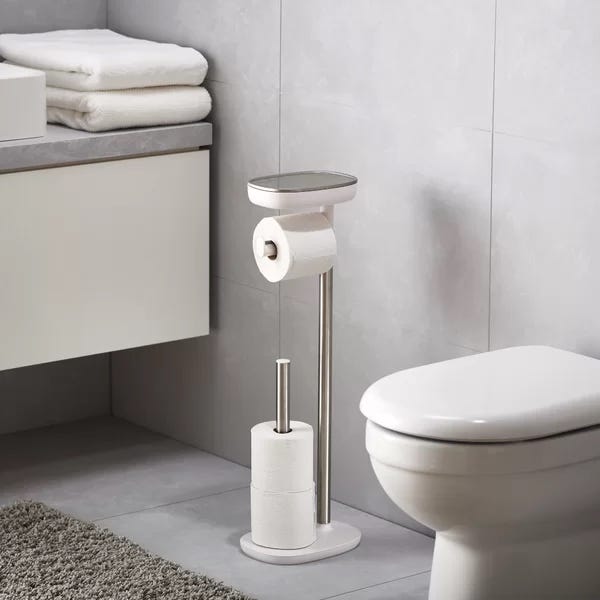 bathroom setting featuring a toilet roll holder and neatly stacked towels