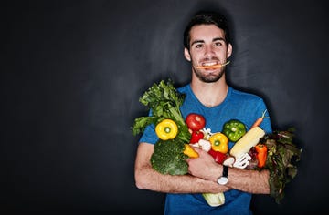 deportista sosteniendo frutas y verduras
