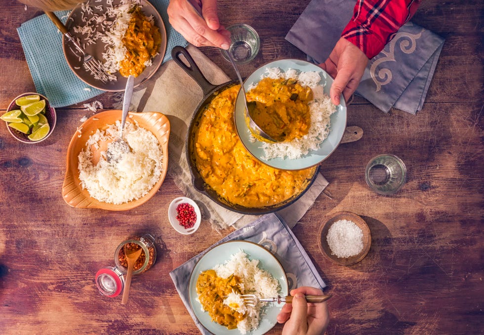 eating delicous homemade chicken curry dish with rice