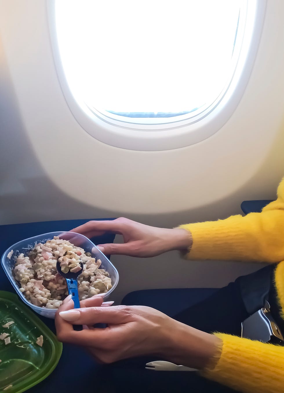 woman eating meal in airplane