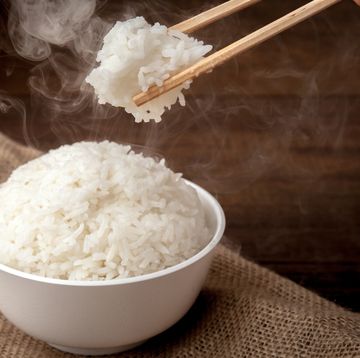 eating rice by using chopsticks on wooden background