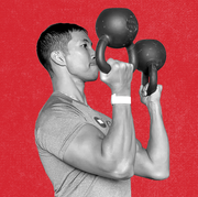 man holding two kettlebells in bottoms up position