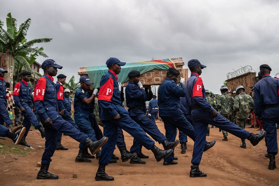 Politieagenten dragen de kist van Tabu Amuli Emmanuel 50 van het Matandaziekenhuis naar de begraafplaats Tabu politieman en vader van zes kinderen werd gedood door gewapende mannen toen hij het behandelcentrum voor ebolapatinten van Mdecins Sans Frontires trachtte te beschermen